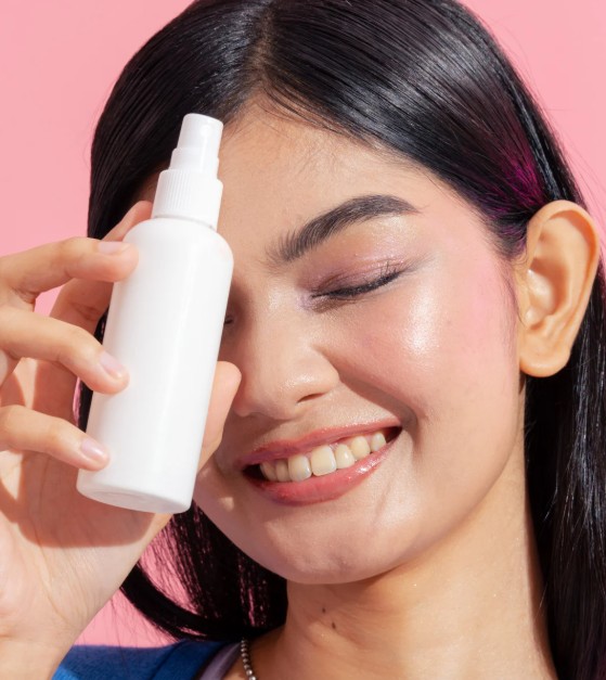 Smiling woman holding product spray